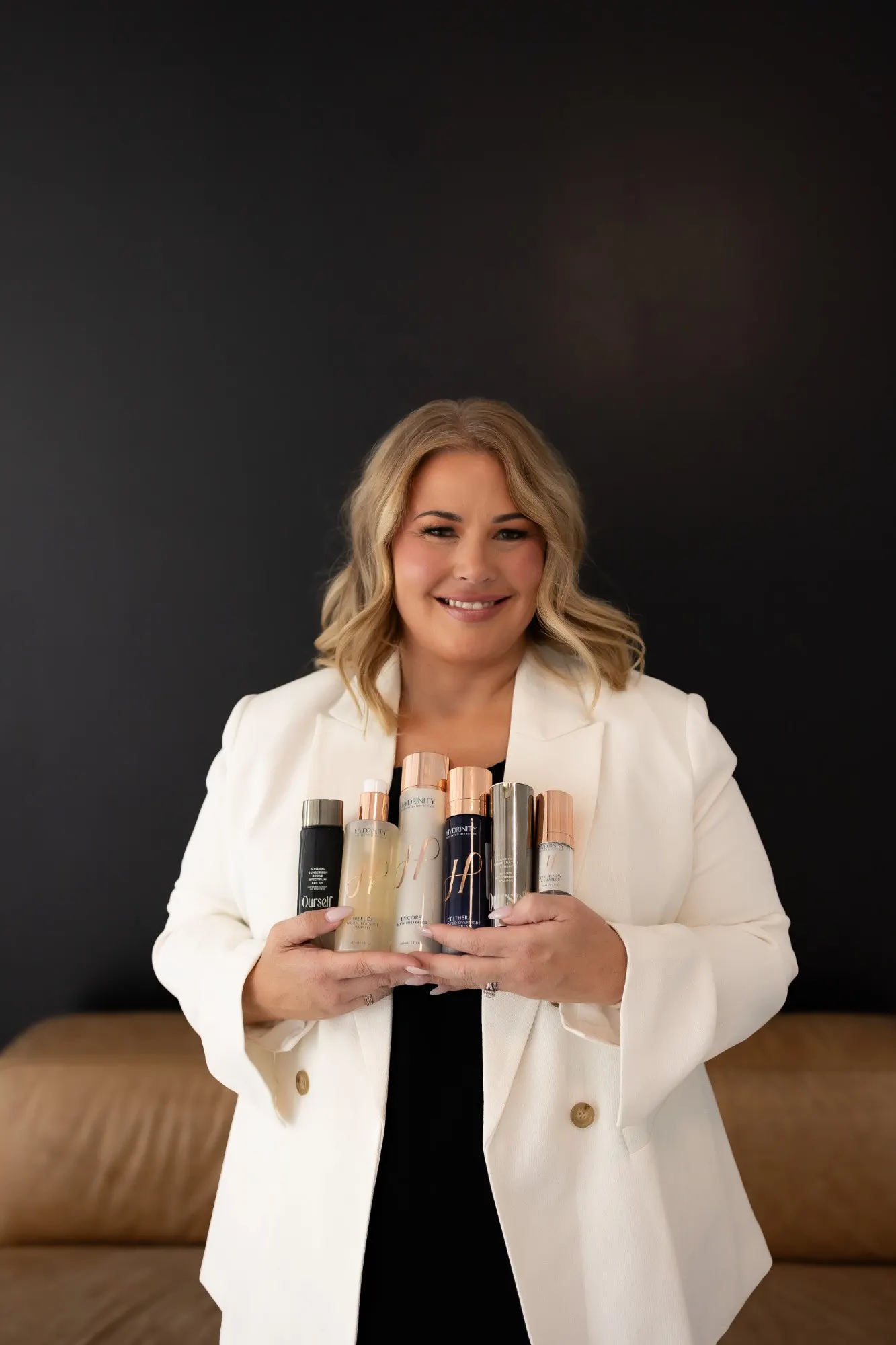 Courtney Etter, RN, holding her favorite Hydrinity and Ourself skincare products